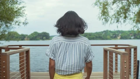 Young Hispanic Woman Walking On Dock By Lake To Get Some Fresh Air, Leans Stock Footage