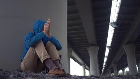 Young homeless man on ground under road bridge. Freedom travel adventure theme Stock Footage 80285912