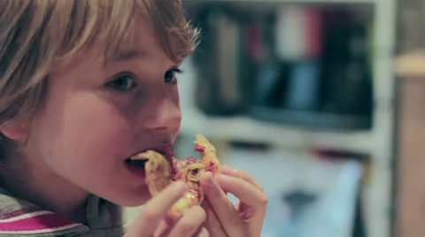 Young hungry cute blonde boy eats pizza quickly Video stock 24276717