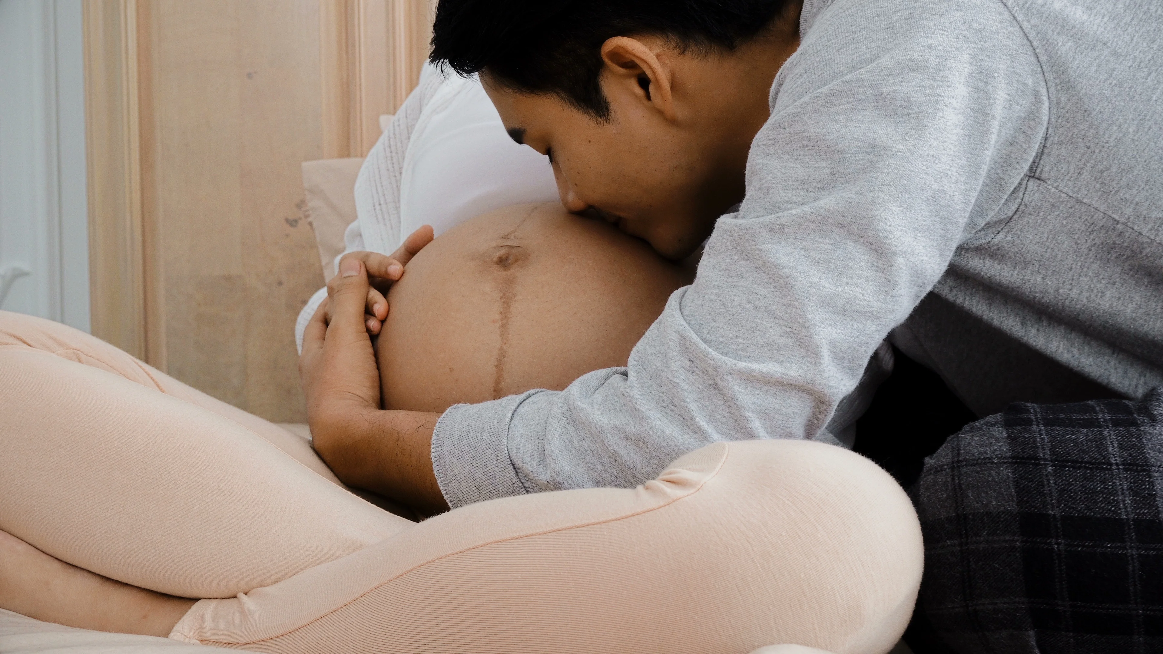 Парень целует живот беременной