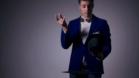 Young illusionist performing tricks with hat and rabbit Stock Footage 80117976