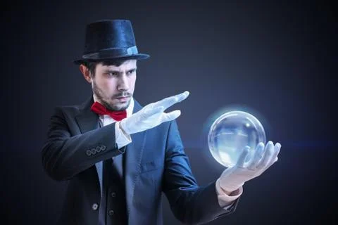 Young illusionist is predicting future and fortune telling from magical ball. Stock Photos