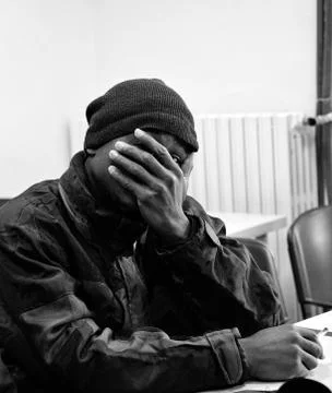 A young immigrant hide his face Stock Photos