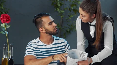 Young independent middle eastern man giving meal order to waiter in cafe. Stock Footage 199634956