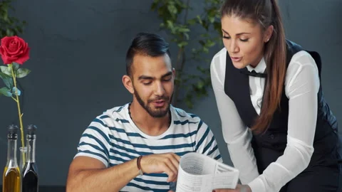 Young independent middle eastern man giving meal order to waiter in cafe. Stock-Footage 199634973