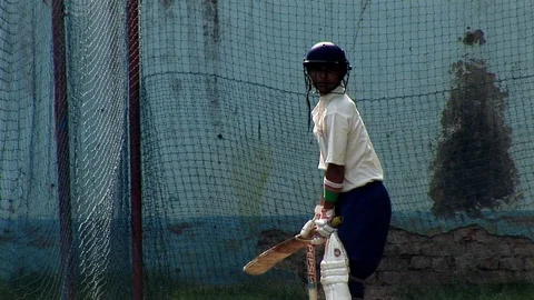 A young indian boy practicing cricket wearing cricket wearing whites and a Vidéo 114121019