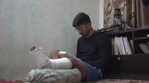 Young indian boy reading a book in the dark with a table lamp, while sitting  Stock Footage 147237293