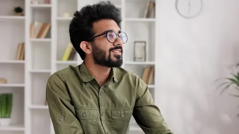 A young Indian boy sits at the table in his living room and starts a new day Stock Footage 255614912