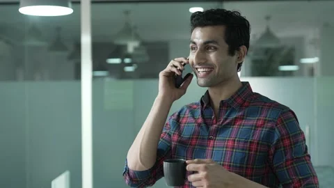 Young Indian businessman talking with client on mobile or smartphone. Видео 170233679