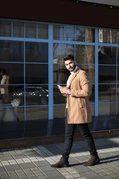 Young Indian businessman using his smartphone at street. Stock Photos