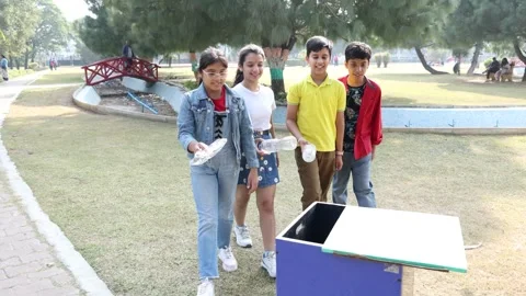 Young indian children throwing plastic bottles into a trash. Garbage recycl.. Vidéo 329091823