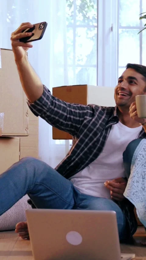 Young Indian couple celebrates relocation, capturing happy memories Stock Footage 343405805