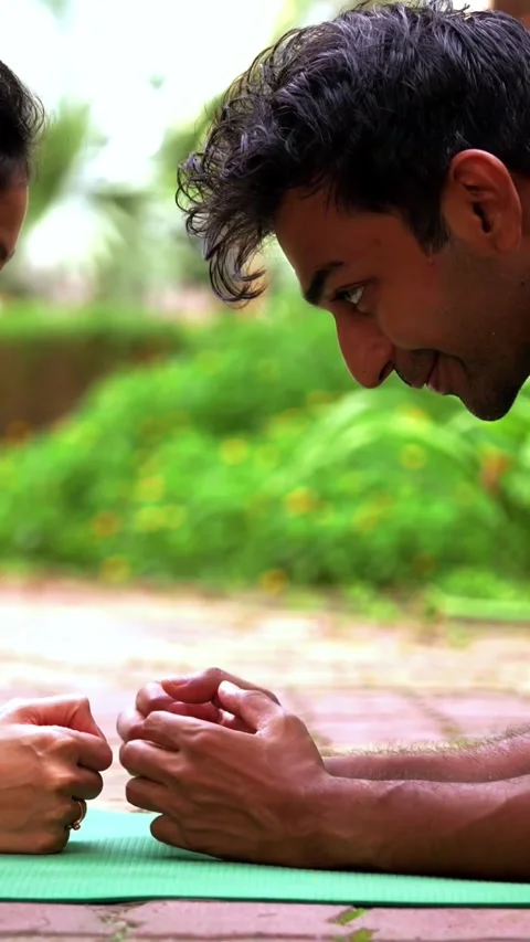 Young Indian couple doing plank exercise facing each other outdoors Stock Footage 342843729