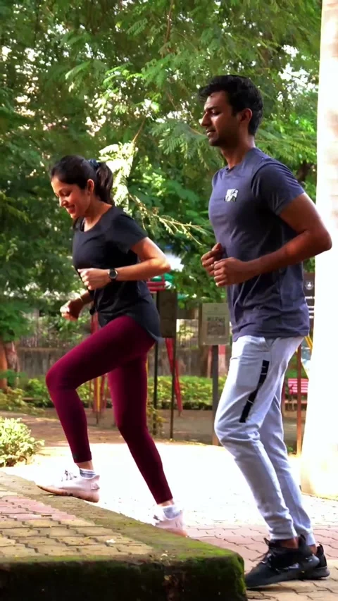 Young Indian couple doing step workout together in outdoor park outdoors Stock Footage 342843720
