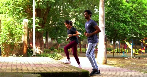 Young Indian couple doing step workout together in outdoor park outdoors Stock Footage 342845195