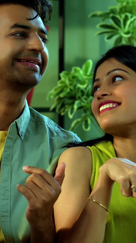 Young Indian couple sitting on sofa having a positive conversation over coffee Vídeo Stock 342689203