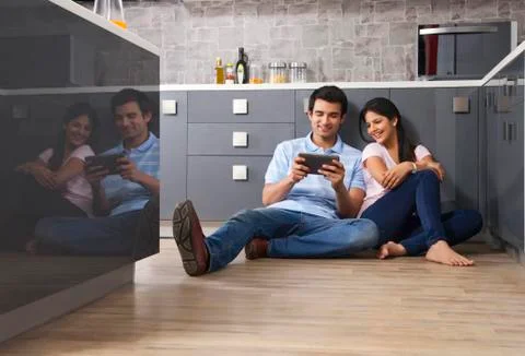 Young Indian couple using digital tablet in kitchen 스톡 사진