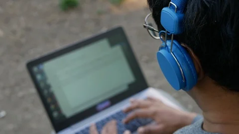 Young Indian freelancer or a student working on a laptop outside wearing blue he Stock-Footage 110968899