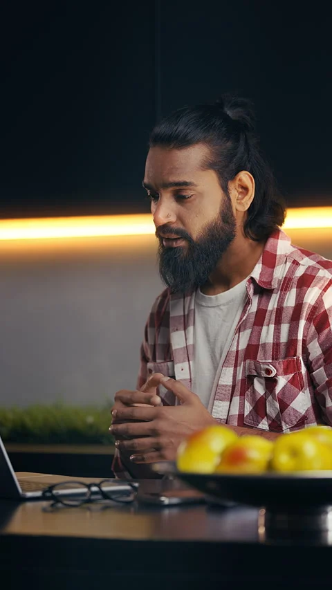 Young Indian game designer brainstorming ideas during video call on his laptop Stock Footage 316838064