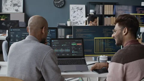 Young Indian IT Professionals Analyzing Data and Code on Laptop in Office Stock Footage 337480249