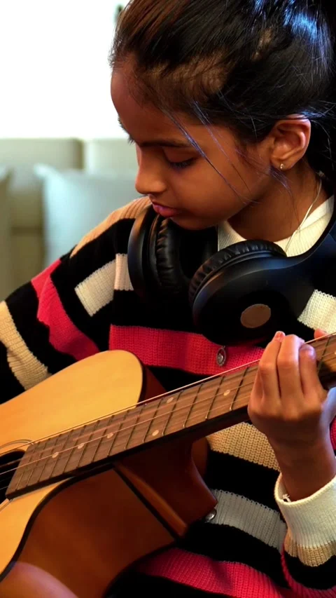 Young Indian kid practicing acoustic guitar at home online Stock Footage 343214314