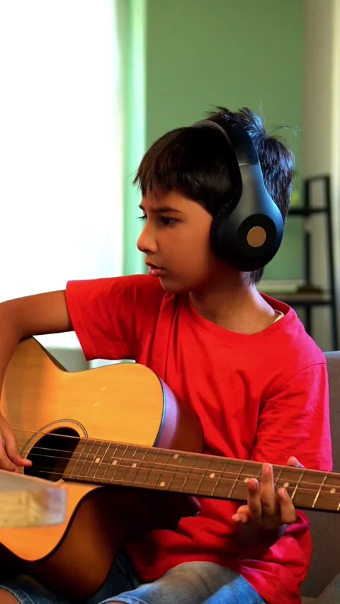 Young Indian kid practicing acoustic guitar at home online Stock-Footage 343214551