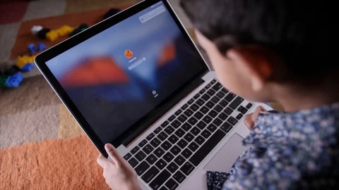A young Indian kid typing a password on his laptop screen to unlock - Technol... Stock Footage 114054936