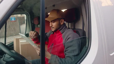 Young indian man courier using tablet while delivering parcel Stock Footage 152558220