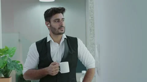 Young indian man feeling sad while standing at office drinking  on tea. Video stock 168218933