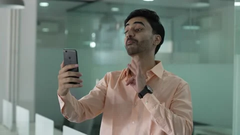 Young Indian man making a video call smiling and talking with her friend. Vídeo Stock 170418200