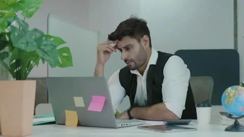 Young Indian man office worker sitting at workplace holding hands massages. Stockbeeldmateriaal 168226434