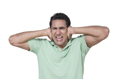 Young Indian man, pained expression from noise/sound, holding his head/ears w... Stock Photos