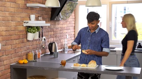 Young Indian man preparing breakfast and girlfriend stolen piece of bread. Stock Footage 119300381
