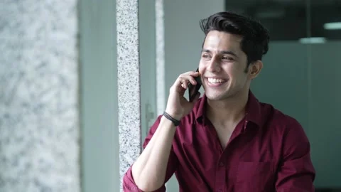 Young indian man talking mobile phone with modern office building. Video stock 170223370