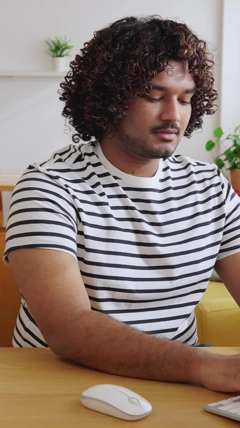 Young Indian man using computer in modern home office Stock Footage 345094551