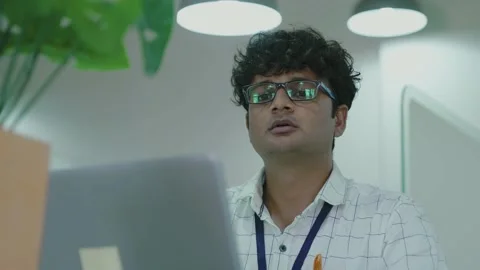 Young indian man using laptop planning for success in modern office. Stock Footage 163402816