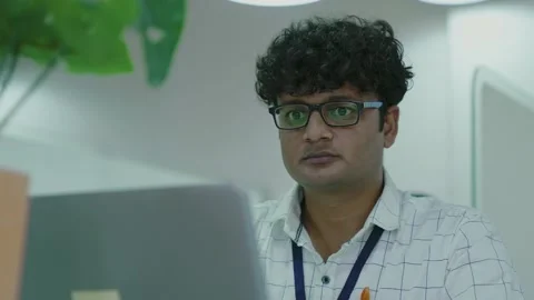 Young indian man using laptop planning for success in modern office. Video stock 168218704