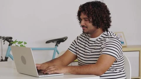 Young Indian man working on laptop at home office Stock Footage 345096217
