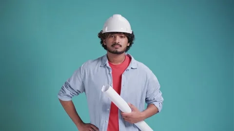 Young indian or arabic man engineer with paper, confident professional on a blue Video stock 238772230