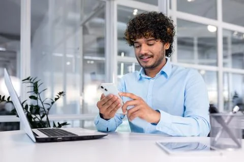 Young indian programmer inside modern office sitting at workplace, man using Stock Photos