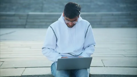 Young indian programmer working on laptop outdoor Stock Footage 310251112