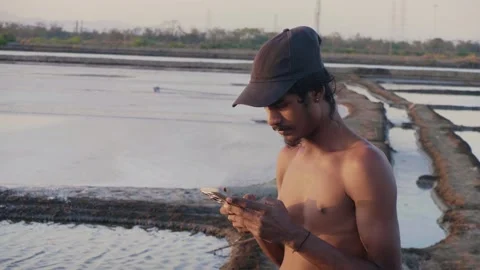 Young Indian shirtless male using a mobile phone to type a text message Vídeos de archivo 337092953