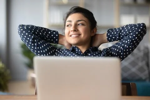 Young indian woman crossed hands behind head, enjoying break time. Stock Photos