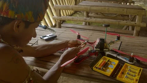 Young indigenous man working on a construction of a drone he is connecting Stock Footage 113179876