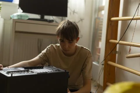 A young individual is assembling a computer in a home setting today Stock Photos