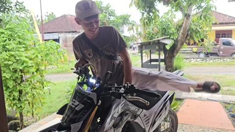 Young Indonesian Man Mounting A Modified Dirt Bike On A Porch Видео 332646793