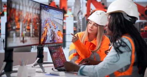 Young Industrial Engineer Studies Car Model On Laptop In Factory Room. Stock Photos