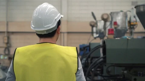 Young industrial engineer walking inside factory facilities and checking on Stock Footage 107100535