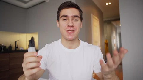 Young influencer using hand sanitizer in video blog 스톡 동영상 128763809