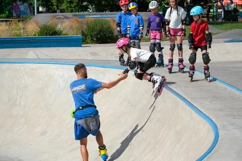 Young inline skater learning bowl skating with coach Stock Photos